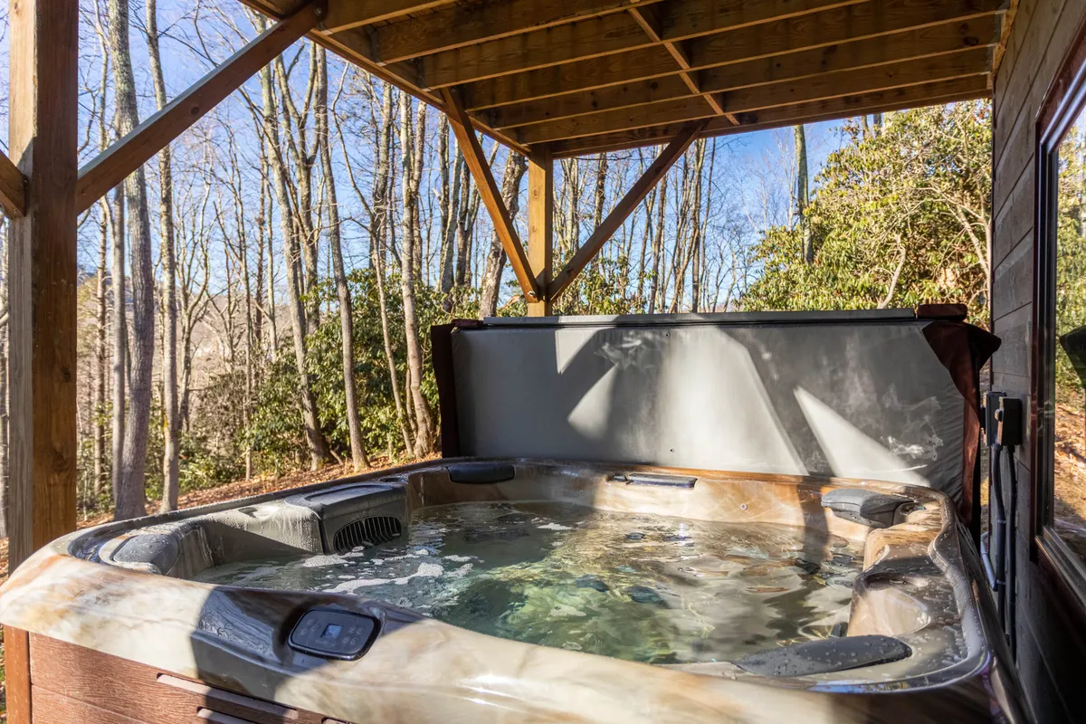 An exterior view of a hot tub nestled among trees and a wooden structure, suggesting tranquility and year-round relaxation. The scene evokes the idea of unwinding after an active day, as described in the section.